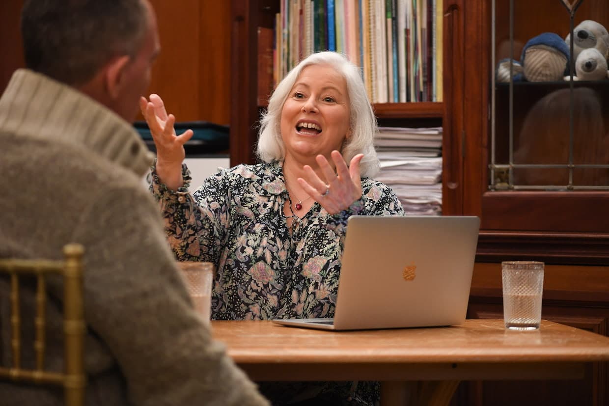 Woman enthusiastically talking with man at table.