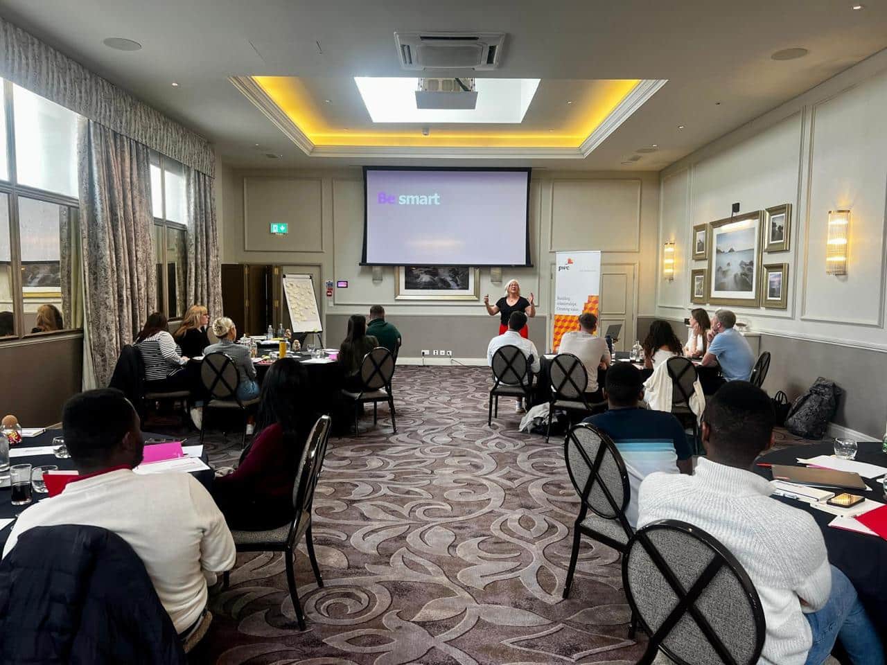 People attending business presentation in conference room.