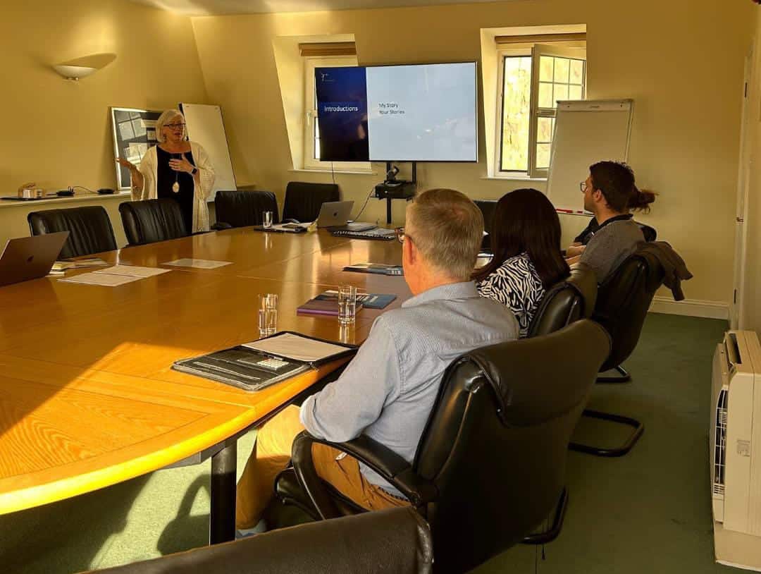 People in meeting room with presentation screen.